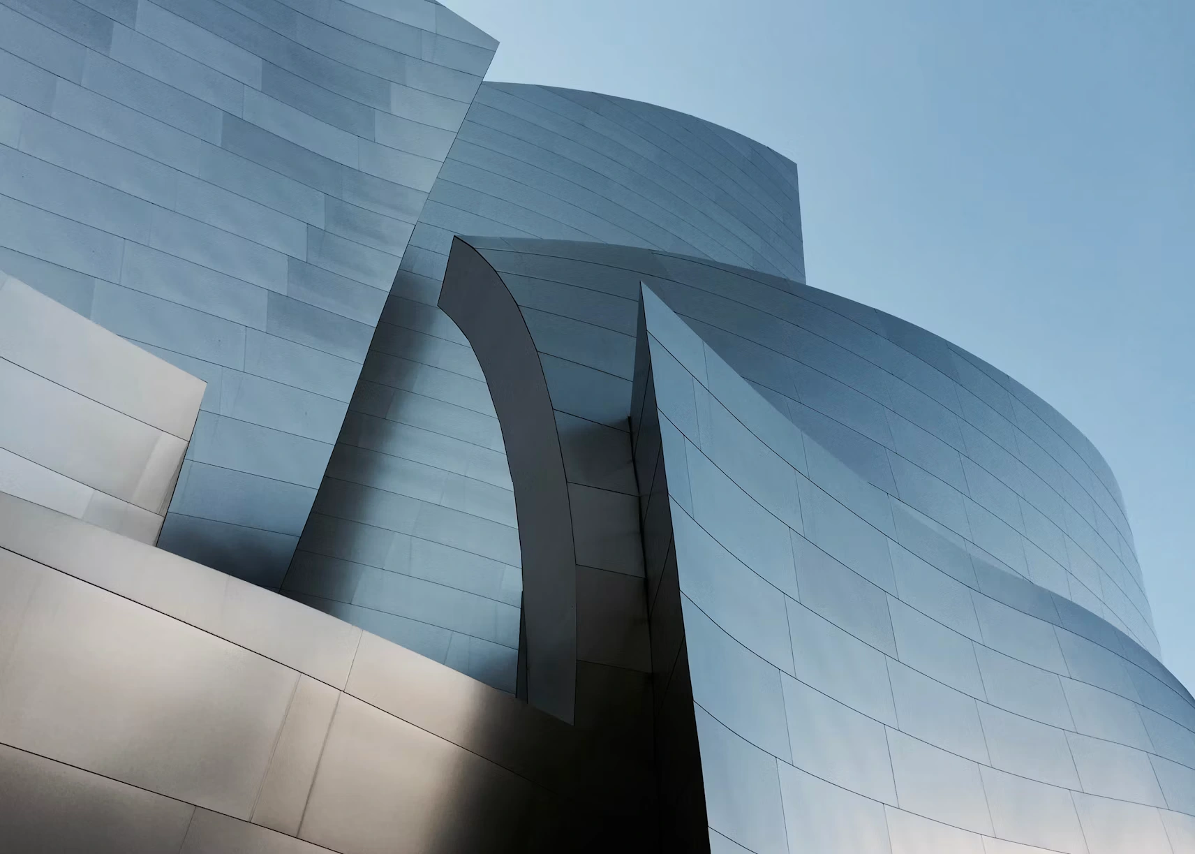 Curved metal façades of contemporary architecture in steel blue and silver tones